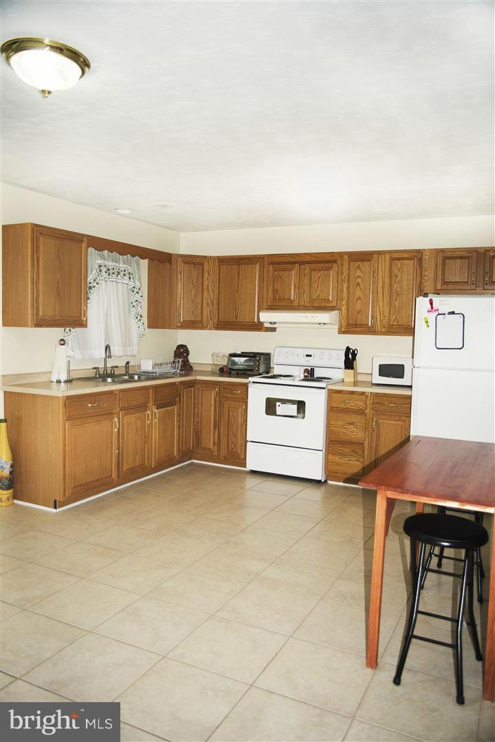 100 Valley Branch Drive Ranson, WV 25438 - Photo 6 of 8 a kitchen with stainless steel appliances granite countertop a stove top oven a sink dishwasher and white cabinets