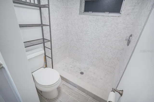 an empty room with fan and windows