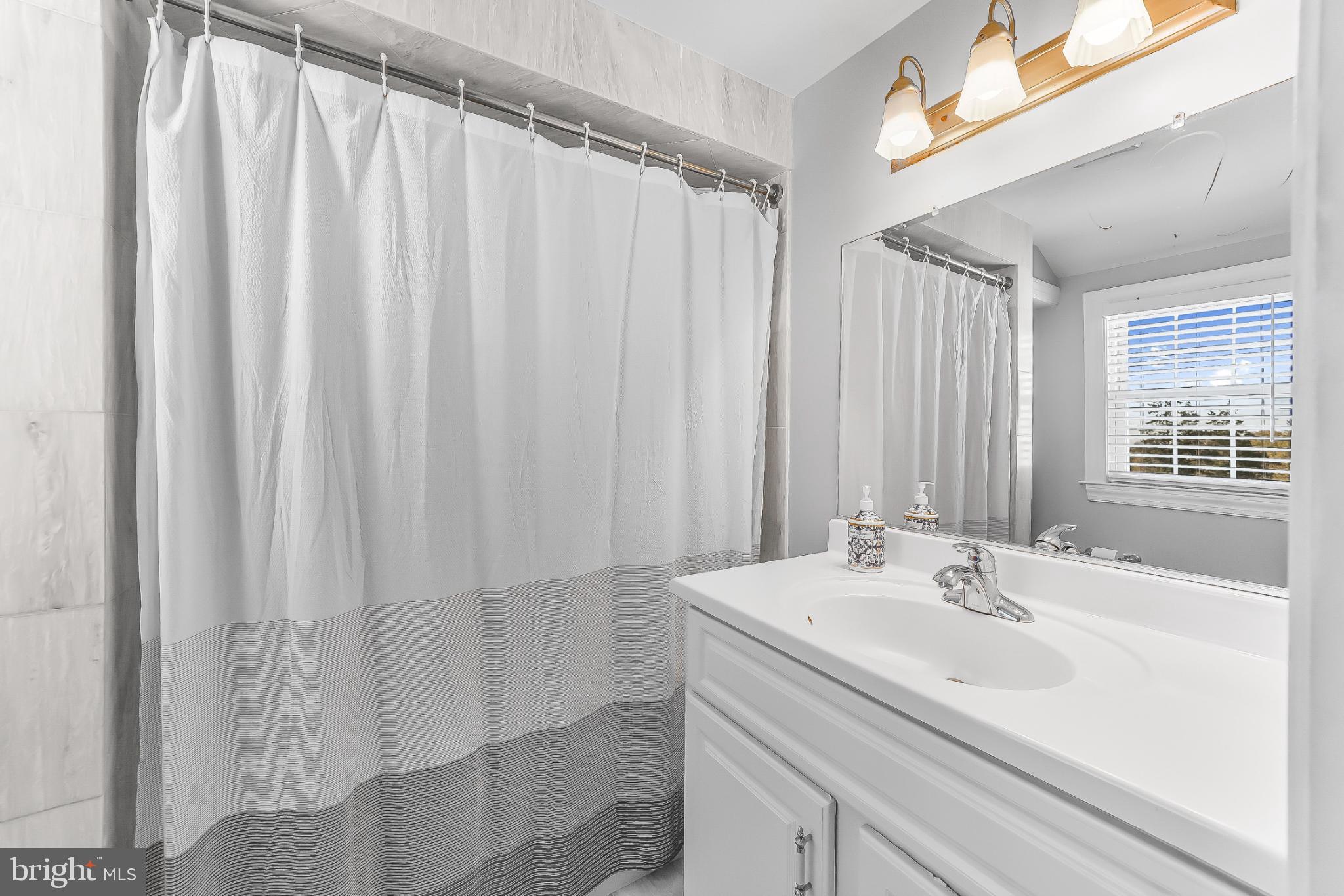 565 Kirk Road Springfield, PA 19064 - Photo 30 of 41 a bathroom with a sink and a mirror