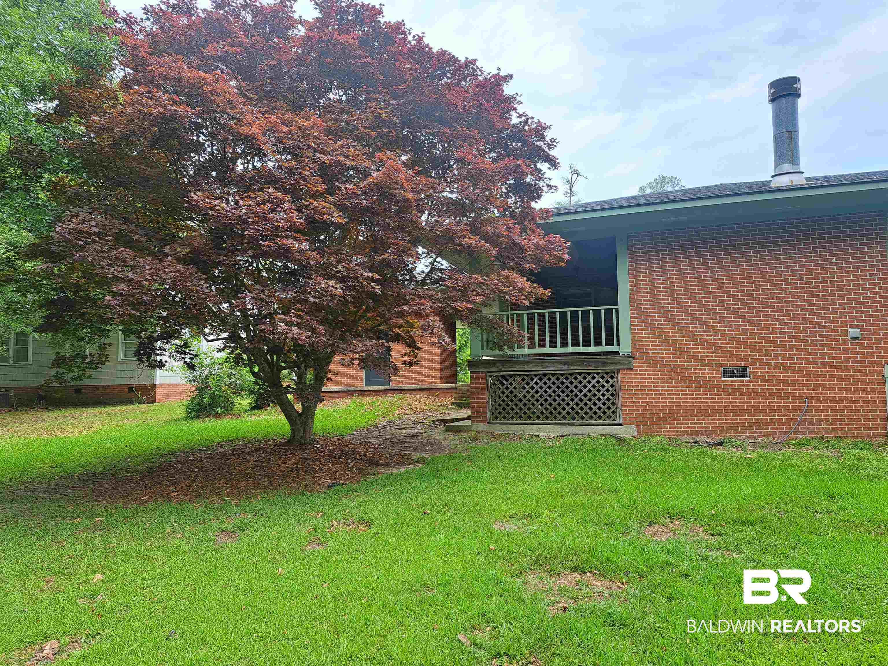 249 Newton Parkway Evergreen, AL 36401 - Photo 25 of 28 View of side of home with crawl space, a lawn, and a deck