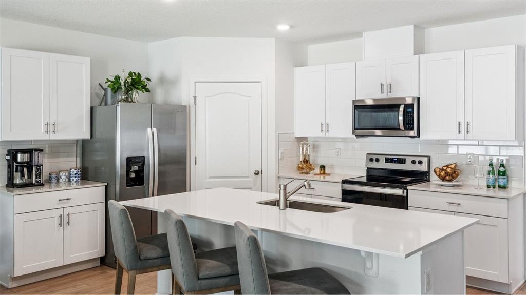 5224 Masser Road St. Cloud, FL 34772 - Photo 4 of 18 a kitchen with stainless steel appliances a stove a sink a microwave a refrigerator a stove a dining table and chairs