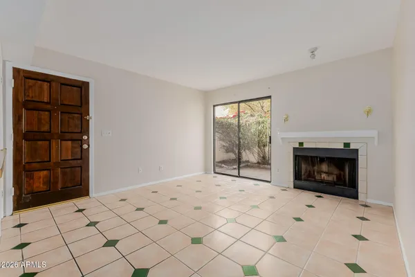a view of empty room with fireplace and window