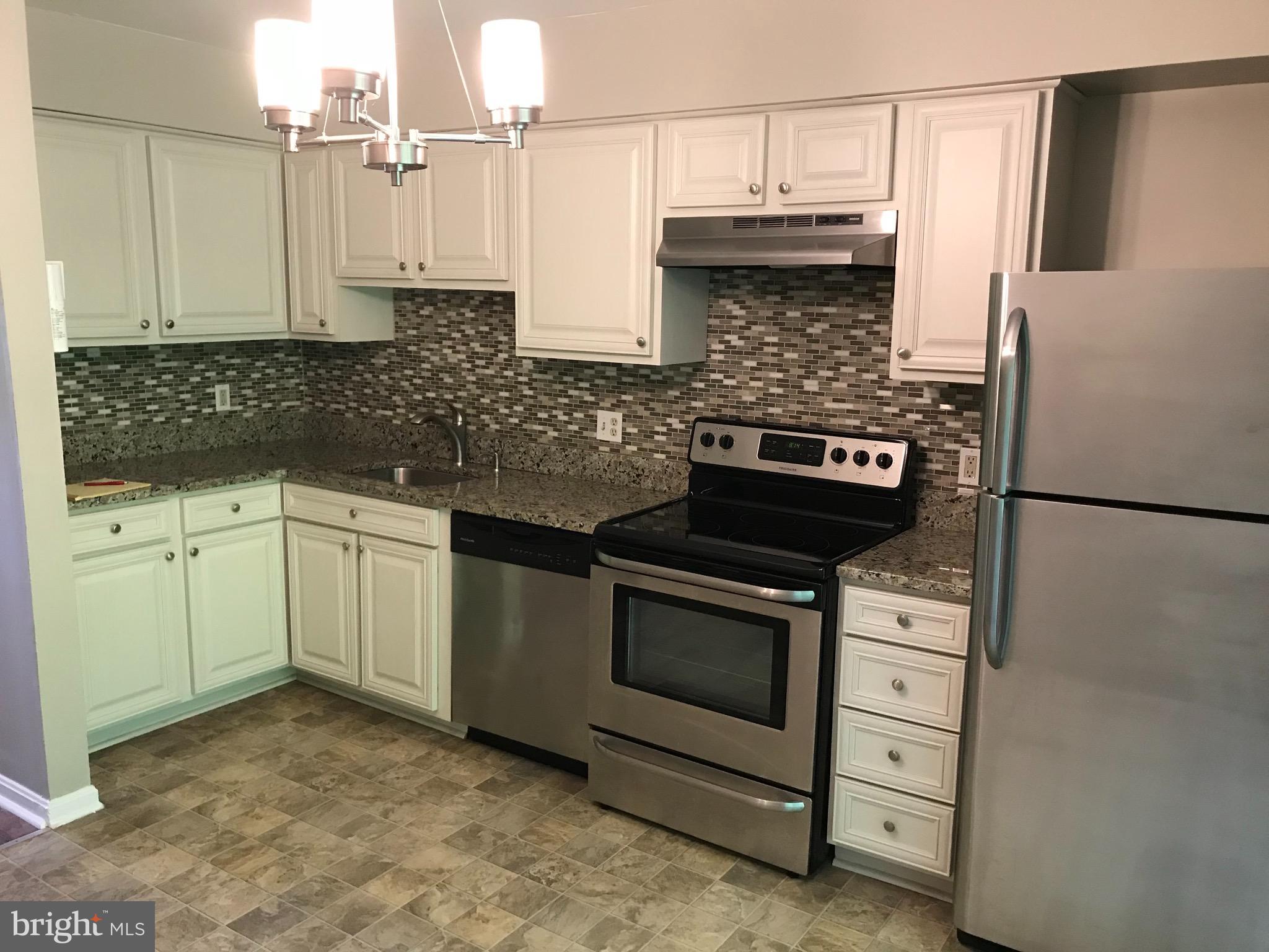 974 Riversedge Circle Annapolis, MD 21401 - Photo 4 of 9 a kitchen with granite countertop a sink stove and cabinets