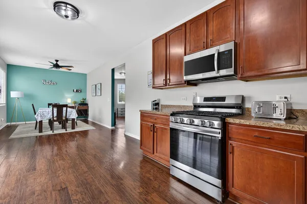 a kitchen with stainless steel appliances granite countertop a stove top oven a sink dishwasher and a microwave oven with cabinets