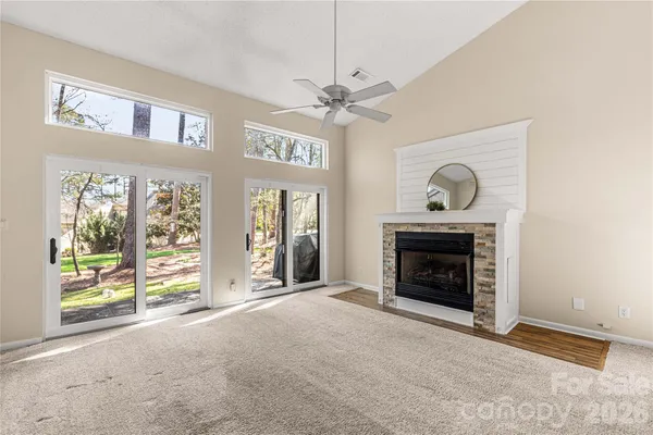 a view of an empty room with a fireplace and a window