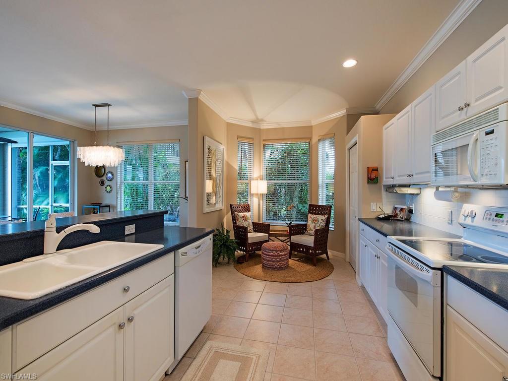 3220 Hamlet Drive, Unit 2 Naples, FL 34105 - Photo 7 of 17 a large kitchen with granite countertop a sink and white cabinets