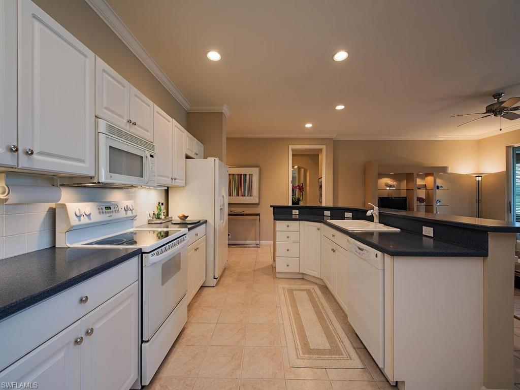 3220 Hamlet Drive, Unit 2 Naples, FL 34105 - Photo 8 of 17 a large white kitchen with stainless steel appliances granite countertop lots of counter space and a sink