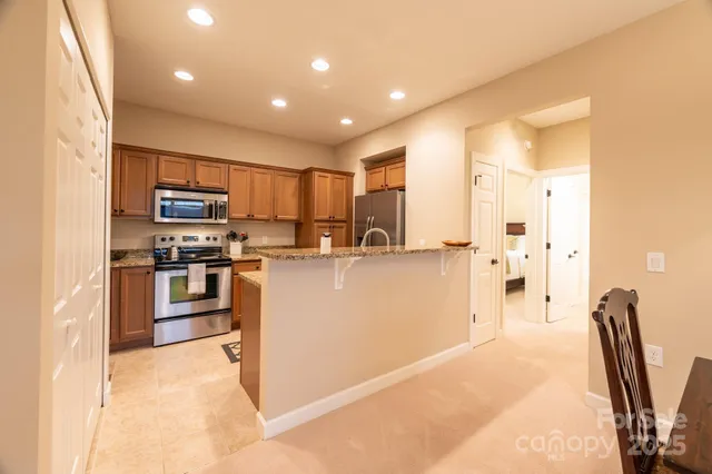 a kitchen with stainless steel appliances granite countertop a stove a sink dishwasher and a refrigerator