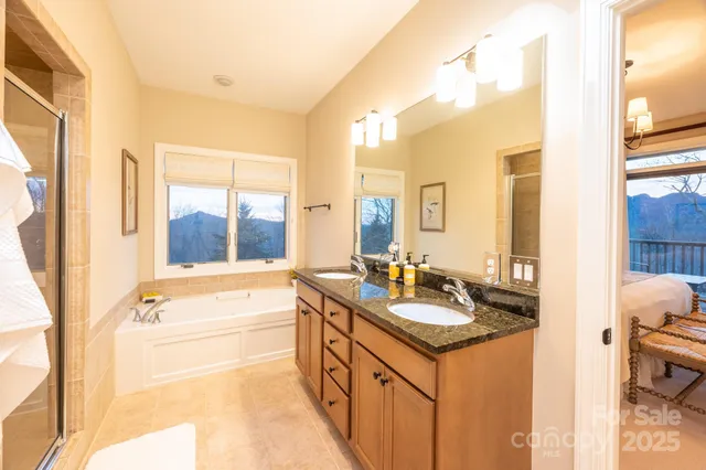 a bathroom with a granite countertop tub sink and mirror