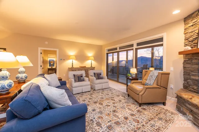 a living room with furniture a large window and a fireplace