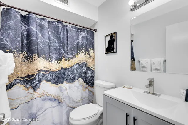 a bathroom with a sink vanity mirror and toilet
