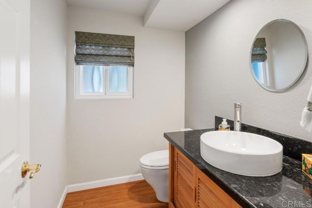 14040 Old Station Road Poway, CA 92064 - Photo 20 of 53 a bathroom with a granite countertop toilet a sink and a mirror
