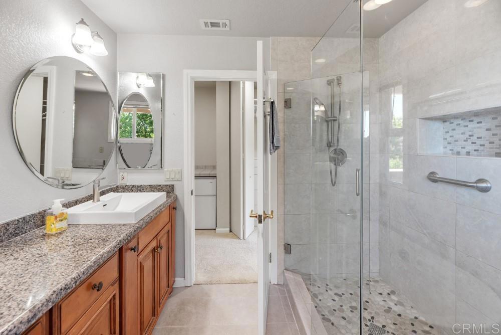 14040 Old Station Road Poway, CA 92064 - Photo 26 of 53 a bathroom with a granite countertop sink mirror and shower