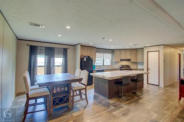 a kitchen with kitchen island a sink table and chairs