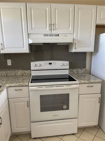 a stove top oven sitting inside of a kitchen