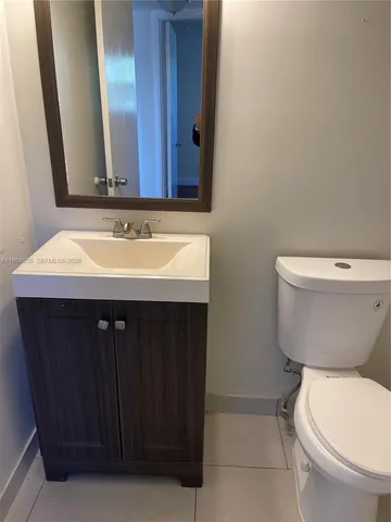 a bathroom with a toilet a sink and mirror