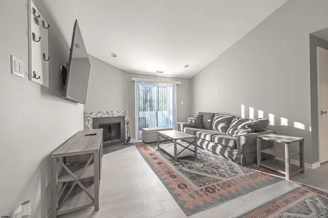 a living room with furniture a rug and white walls