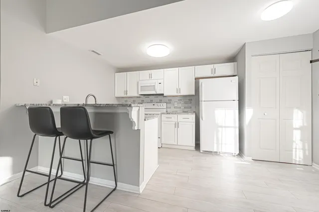a kitchen with a table chairs refrigerator and cabinets