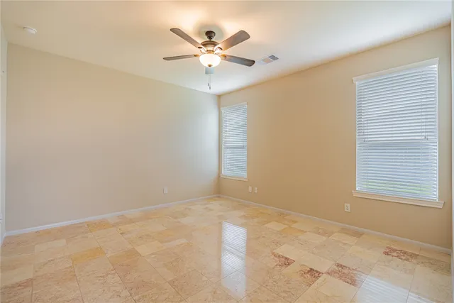 an empty room with a window and a fan