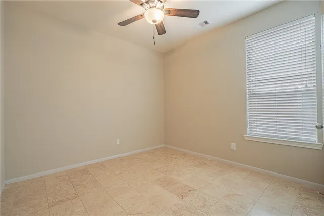 an empty room with a ceiling fan and a shower