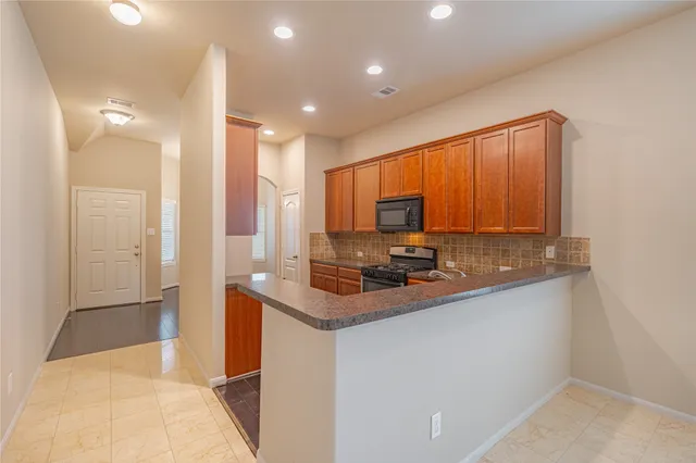 a kitchen with stainless steel appliances granite countertop a sink a stove and a refrigerator