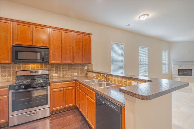 a kitchen with stainless steel appliances granite countertop a sink stove and microwave