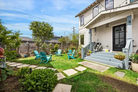 a view of a house with backyard sitting area and garden