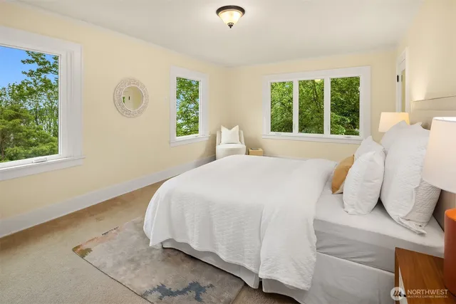 a bed sitting in a bedroom next to a window