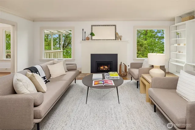 a living room with furniture a large window and a fireplace