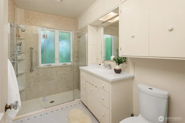 a bathroom with a sink a toilet and shower