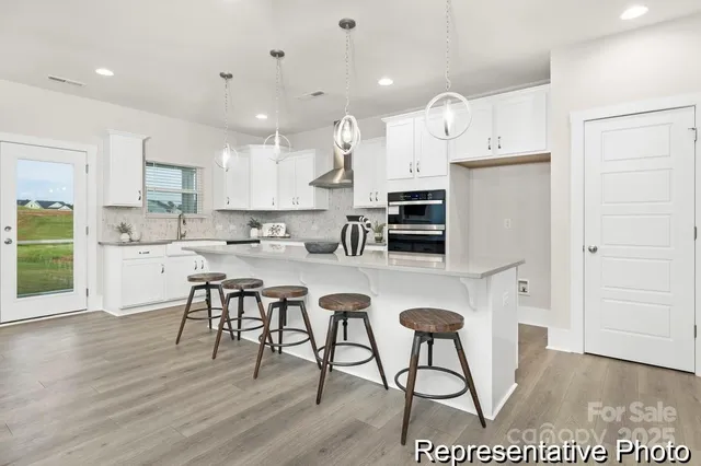 a kitchen with stainless steel appliances kitchen island granite countertop a stove a sink a refrigerator and a cabinets