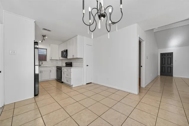 a kitchen with white cabinets and white appliances