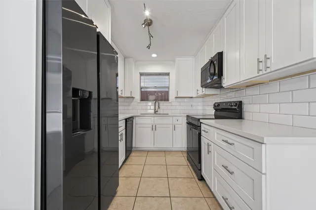 a kitchen with white cabinets stainless steel appliances and a sink