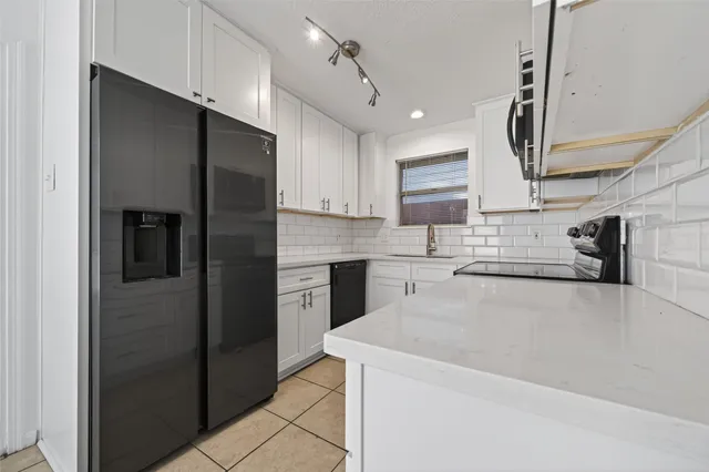 a kitchen with stainless steel appliances a refrigerator sink and cabinets
