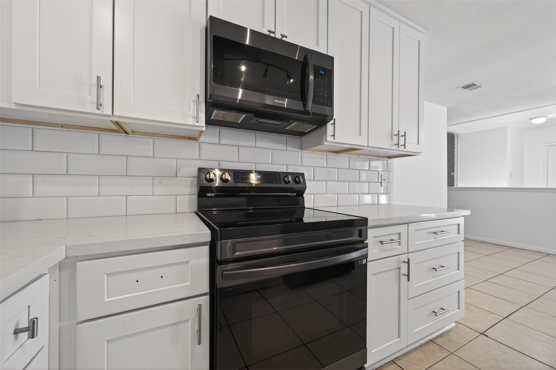 2603 Shady Bayou Lane Spring, TX 77373 - Photo 17 of 43 a kitchen with white cabinets and black appliances