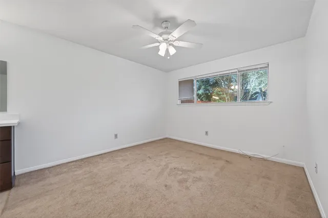 a view of a big room with chandelier fan and windows