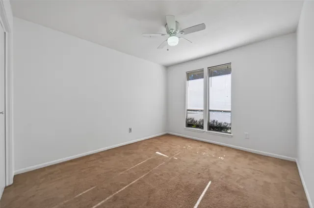 a view of an empty room with a ceiling fan