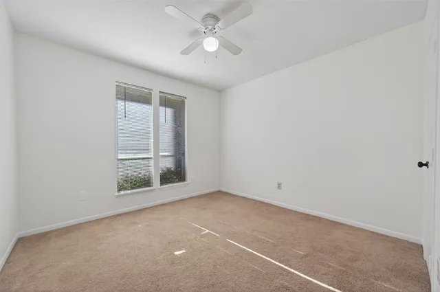 a view of an empty room with a ceiling fan