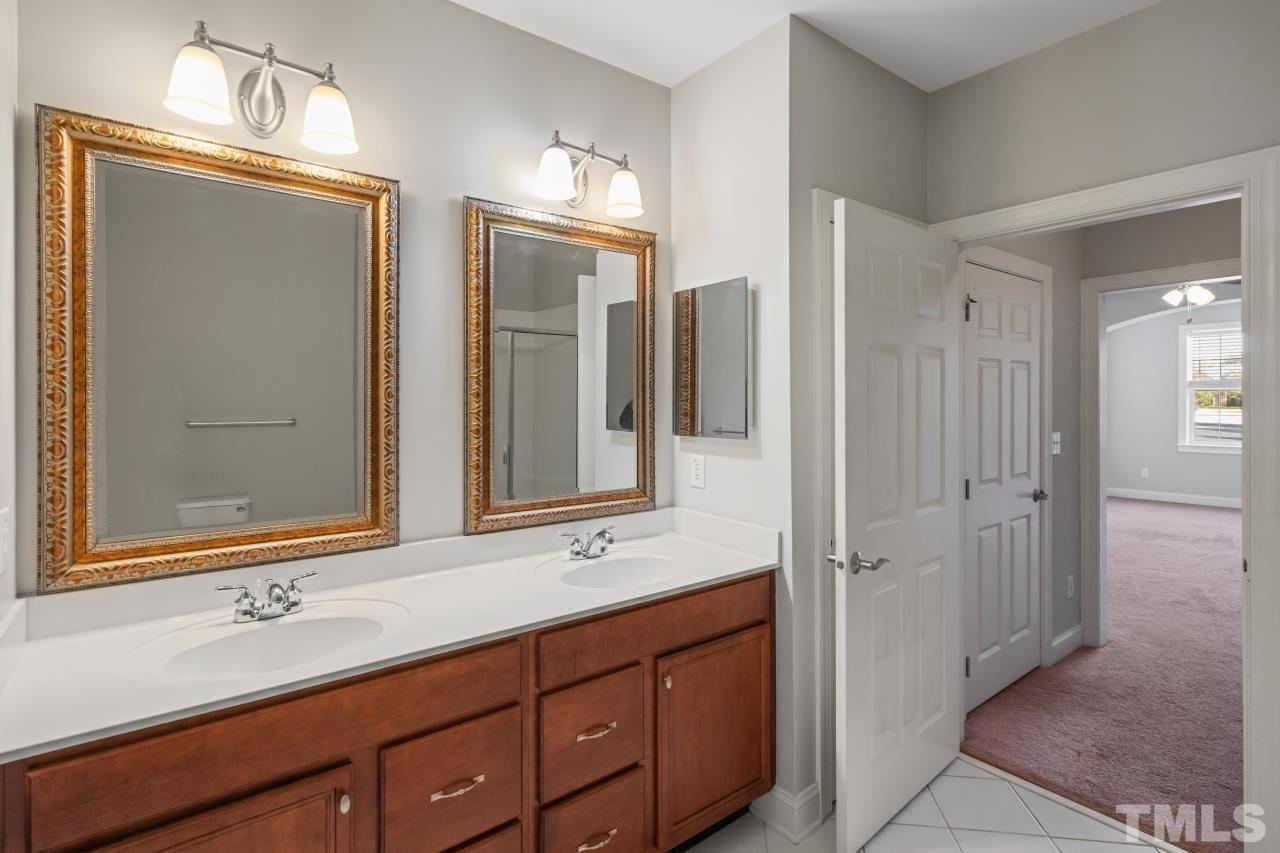 10421 Rosegate Court, Unit 201 Raleigh, NC 27617 - Photo 11 of 12 a bathroom with a double vanity sink mirror and double