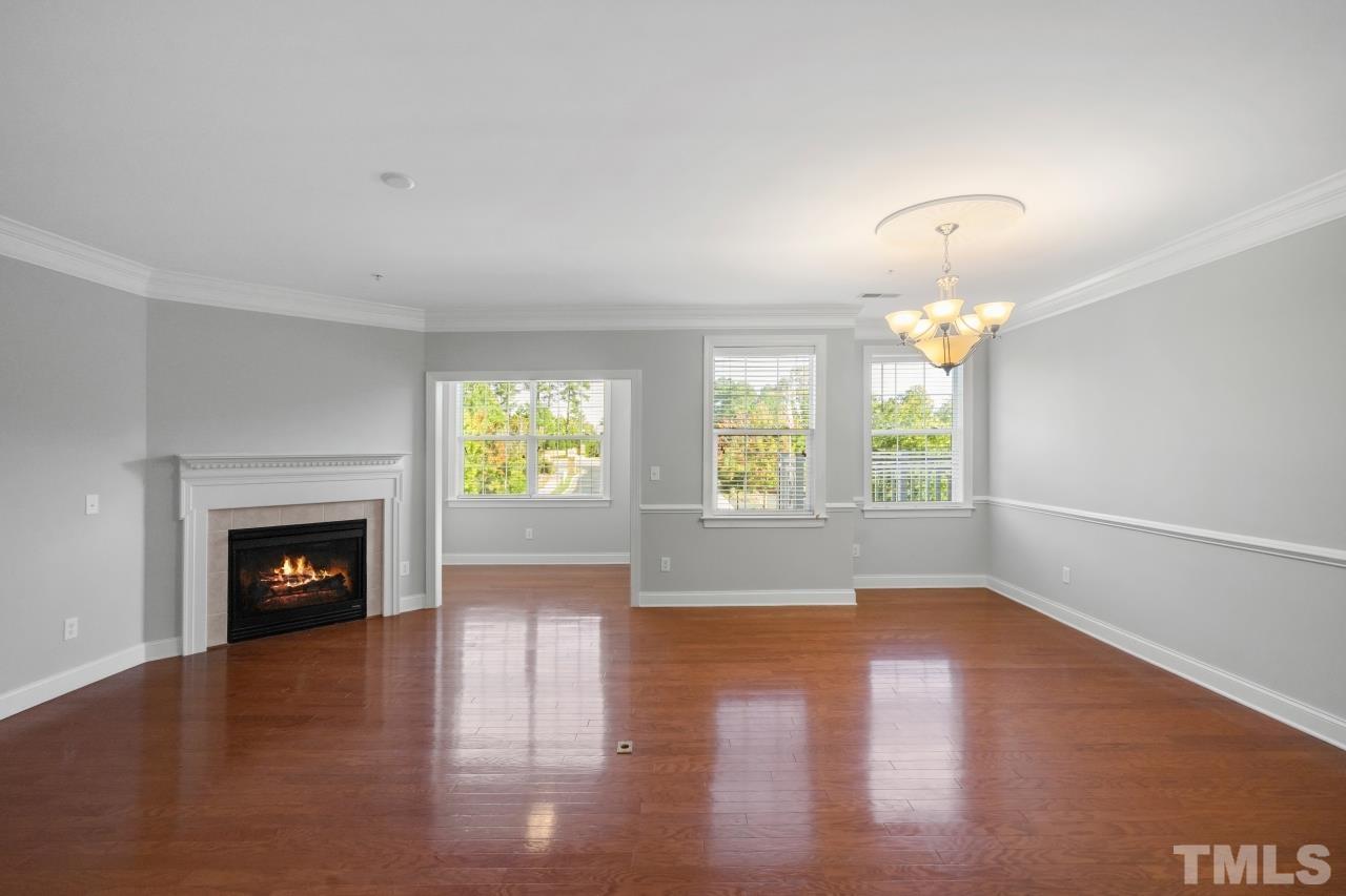 10421 Rosegate Court, Unit 201 Raleigh, NC 27617 - Photo 2 of 12 an empty room with windows fireplace and wooden floor