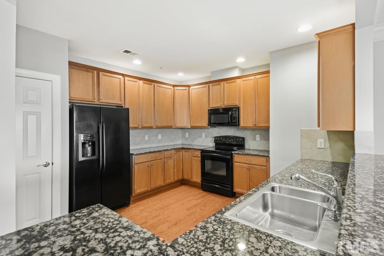 10421 Rosegate Court, Unit 201 Raleigh, NC 27617 - Photo 3 of 12 a kitchen with granite countertop stainless steel appliances granite countertop a refrigerator stove top oven and sink