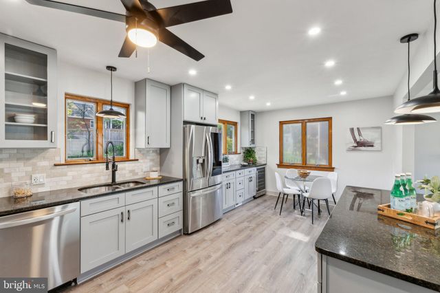 a kitchen with granite countertop a sink appliances cabinets and furniture