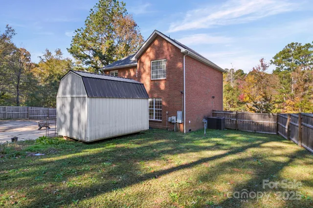 a view of a house with backyard and trees