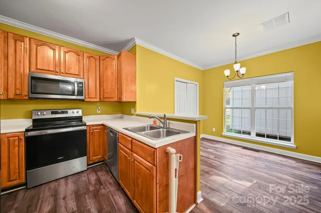 a kitchen with stainless steel appliances granite countertop a sink stove and refrigerator