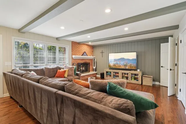 a living room with furniture a fireplace and a flat screen tv