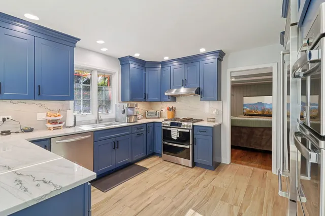 a kitchen with granite countertop a refrigerator stove top oven and sink