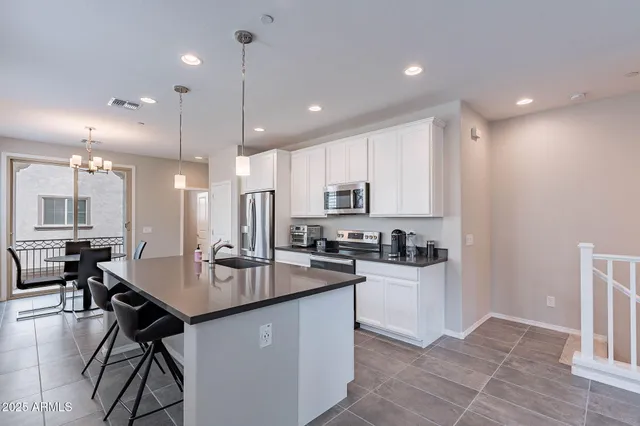 a kitchen with kitchen island a stove a table and chairs in it
