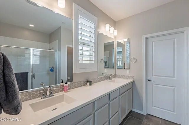 a bathroom with double vanity sink and a mirror