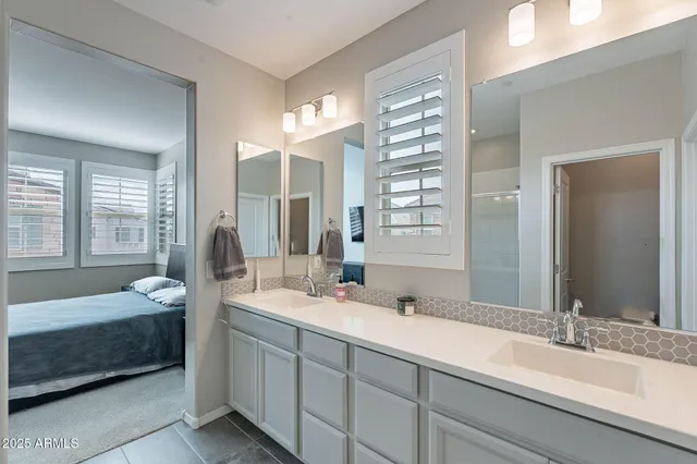 a en suite bathroom with a double vanity sink and a mirror