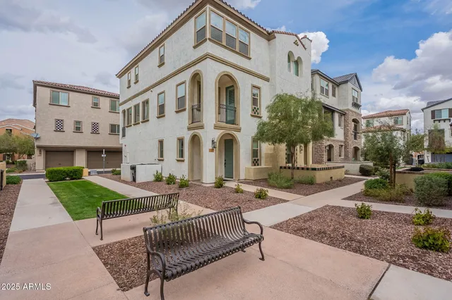 a front view of a house with garden and chairs